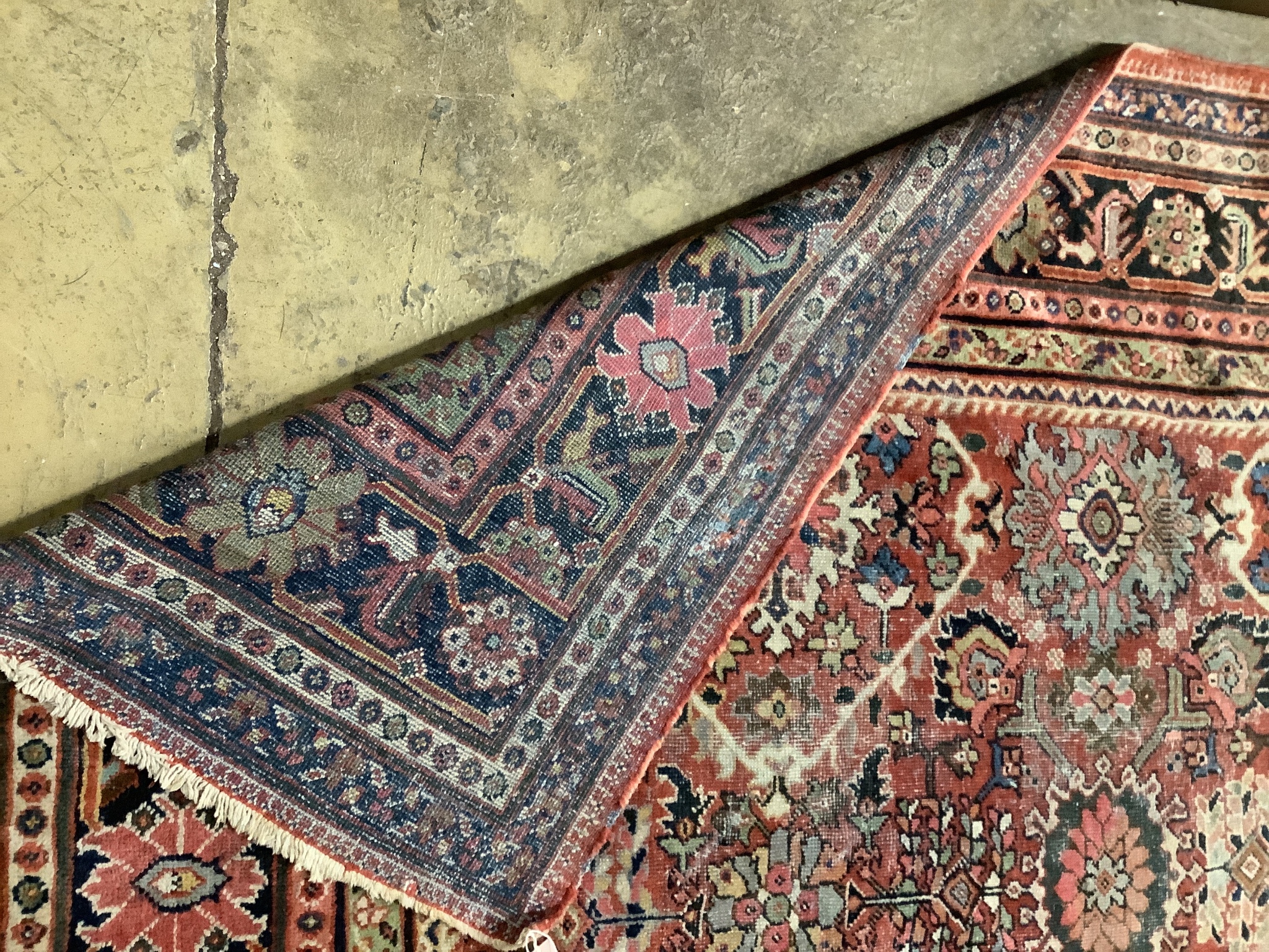 An early 20th century Heriz brick red ground carpet (worn), 418 x 330cm